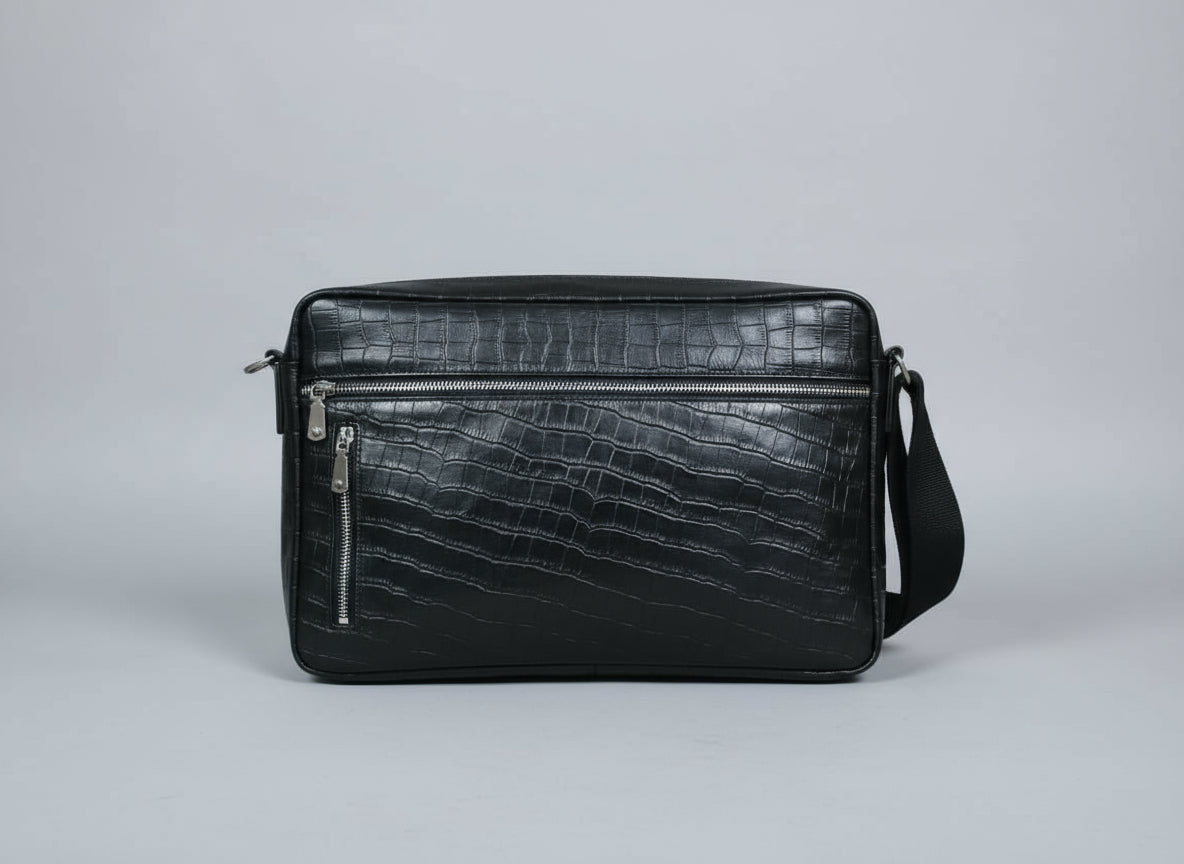 Black crocodile-patterned leather bag on a light gray background
